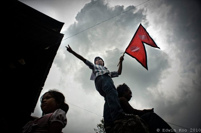 A Nepali youth waves a national flag during peace rally in Kathmandu